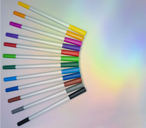 Close-up of colored pencils over white background