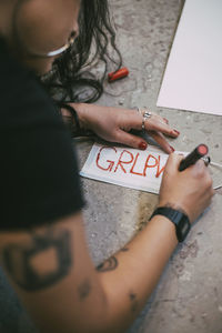High angle view of woman hand with text