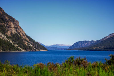 Scenic view of lake against clear blue sky