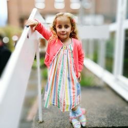 Full length of girl standing by railing at park