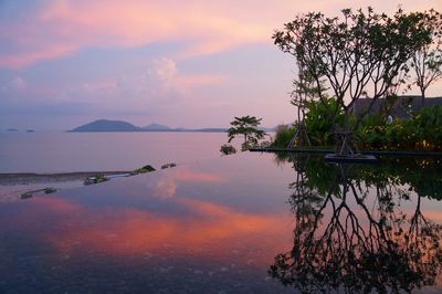 Scenic view of infinity pool against sky during sunset