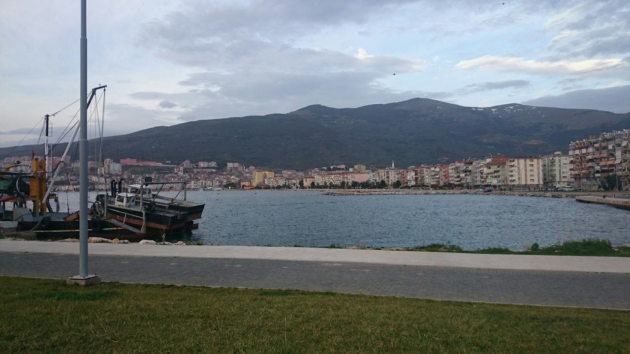 mountain, water, sky, building exterior, mountain range, architecture, built structure, cloud - sky, river, sea, cloud, nautical vessel, lake, nature, transportation, city, day, beauty in nature, house, scenics