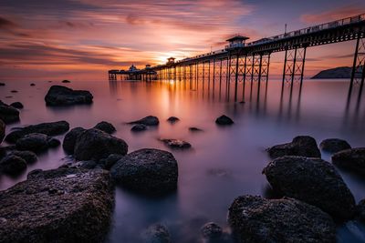 Scenic view of rocks in sea against sky during sunset