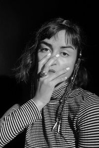 Portrait of teenage girl against black background