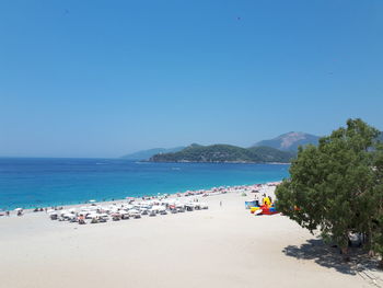 Scenic view of beach against clear blue sky