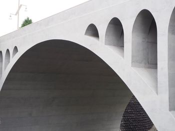 Low angle view of arch bridge against building