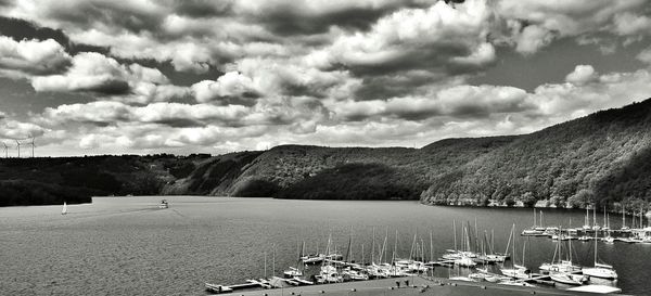 Scenic view of lake and mountains against cloudy sky