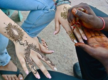 Midsection of woman getting henna tattoo