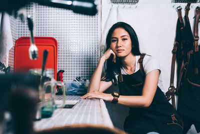 Portrait of young woman sitting on table