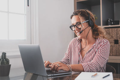 Woman using smart phone while sitting on table