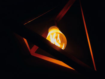 Low angle view of illuminated light bulbs in the dark