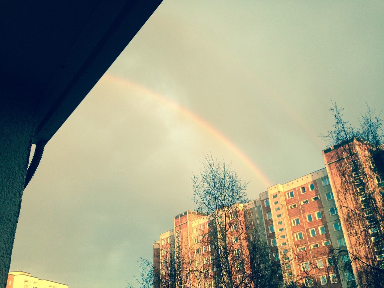 LOW ANGLE VIEW OF RAINBOW OVER BUILDINGS