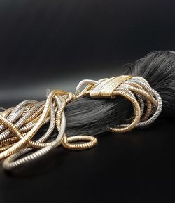 Close-up of rope tied on table against black background