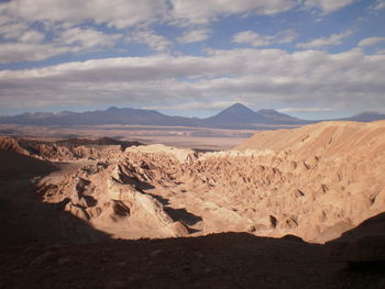 View of desert against cloudy sky