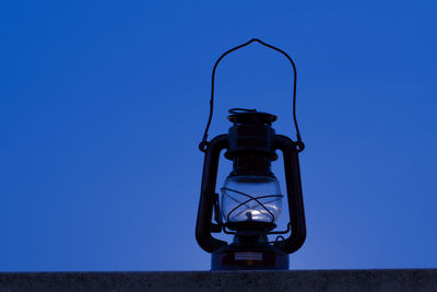 Low angle view of electric lamp against blue sky