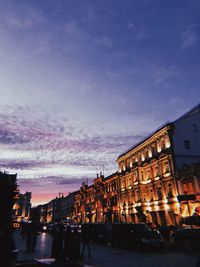 City street and buildings against sky at sunset