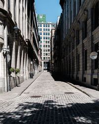 Empty alley amidst buildings in city