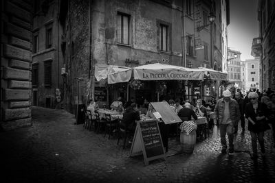 People on street amidst buildings in city
