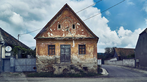 Old building by road against sky