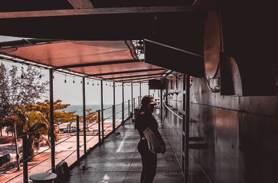 Man photographing woman standing on escalator