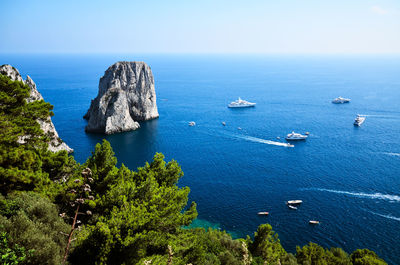 Capri island, faraglioni view from the coast and boats in sea