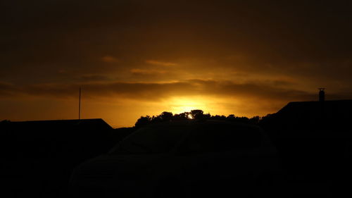Silhouette of car against sky during sunset