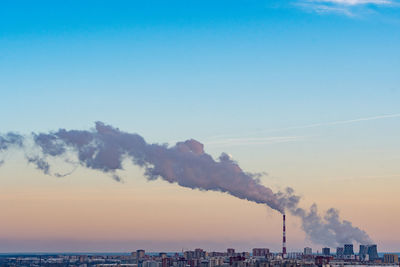 Smoke emitting from chimney against sky