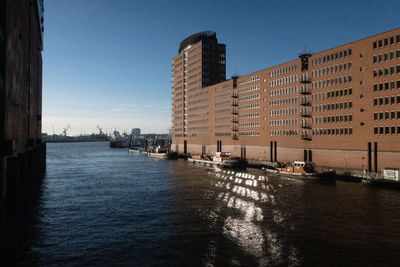 River by buildings against sky in city