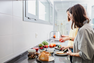 Side view of woman having food at home