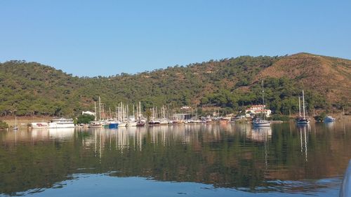 Boats moored in lake against clear sky