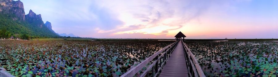 Panoramic view of railroad tracks against sky during sunset