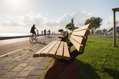 Bench on promenade against sky