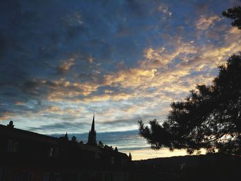 Silhouette of trees and buildings against sky