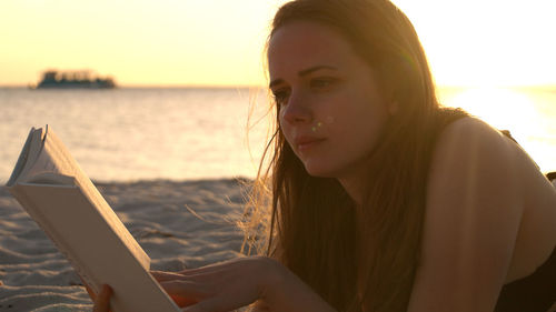 Young woman using mobile phone at beach