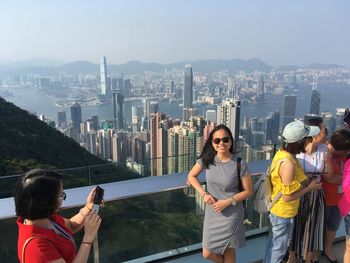 People standing at victoria peak with cityscape in background