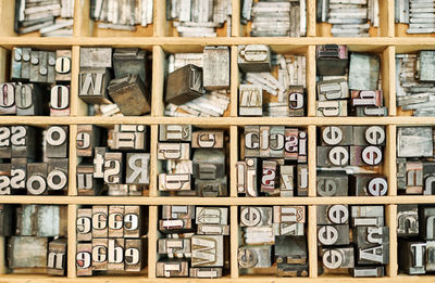 Top view of set of metal shabby letterpress letters placed in wooden box in typography