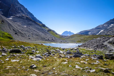 Scenic view of lake and mountains against blue sky