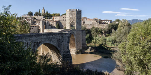 Arch bridge over river against sky