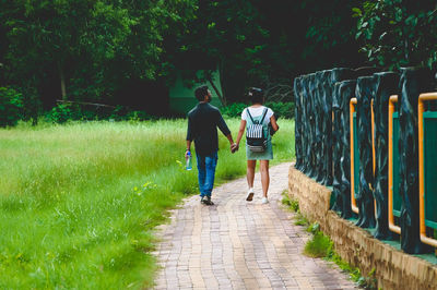 Couple walking on footpath in park