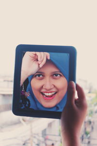 Close-up of smiling young woman reflection in mirror