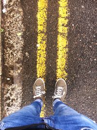 Low section of man standing on road