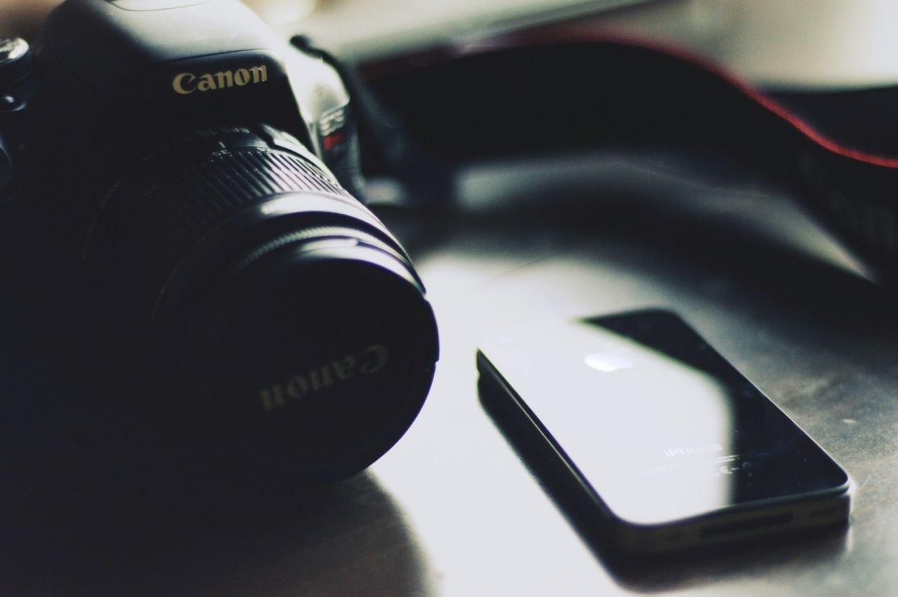 indoors, technology, close-up, communication, photography themes, selective focus, camera - photographic equipment, focus on foreground, black color, wireless technology, music, high angle view, still life, lifestyles, part of, digital camera, leisure activity, reflection