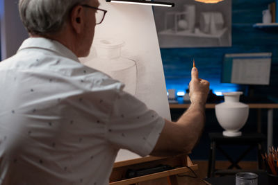 Senior man with gray hair holding pencil