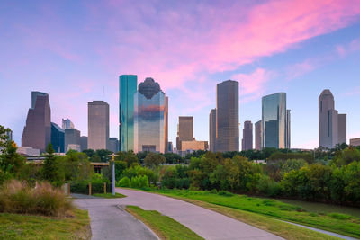 Modern buildings in city against sky during sunset