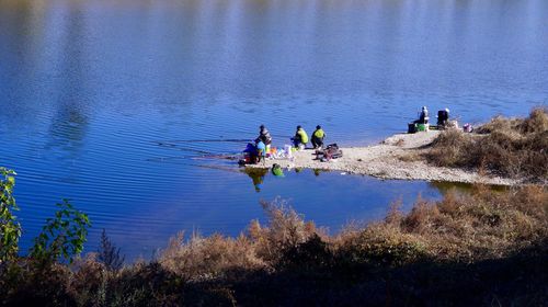 People fishing in lake