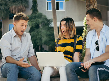 Smiling friends studying together at university campus