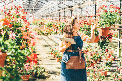 Young woman standing by plants