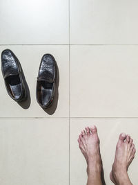 Low section of man standing on tiled floor