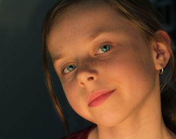 Close-up portrait of girl against wall