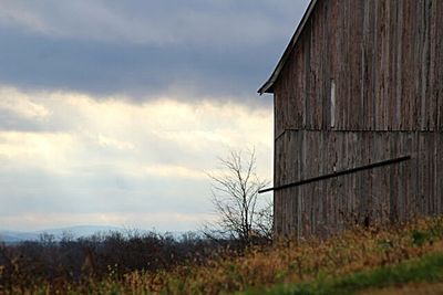 Built structure on field against cloudy sky